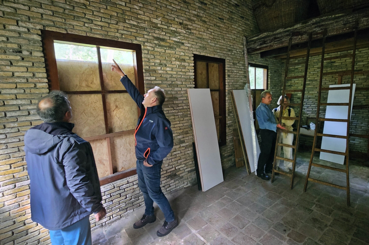 Aannemer Sjoerd de Jong bespreekt de werkzaamheden in het atelier van Le Roy in de ecokathedraal in Mildam met bestuur en bouwmeester